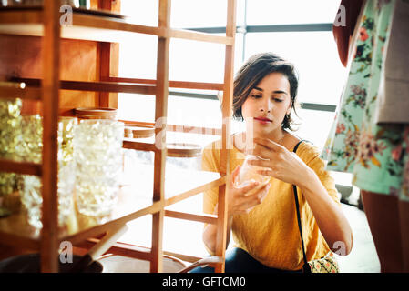 Junge Frau in einem Geschäft ein Glas Stockfoto