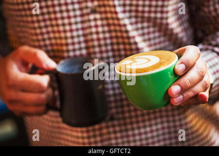 Ein Mann mit einer Tasse frisch gebrühten Kaffee Stockfoto