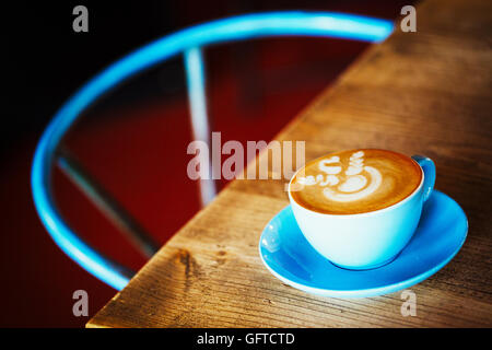 Eine blaue China Tasse und Untertasse mit schaumigen Kaffee Stockfoto