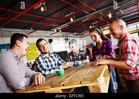 Fünf Personen sitzen um einen Tisch aus Holz Stockfoto