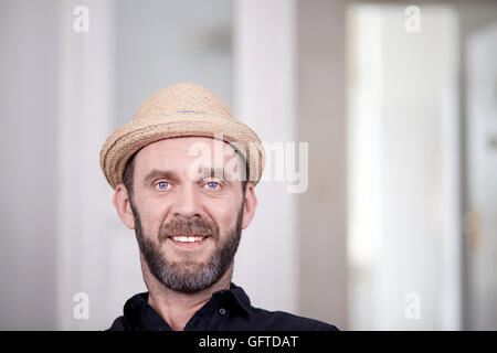 Porträt von freundlich aussehende Hipster mit streunenden Hut hohen Schlüssel gedreht Stockfoto