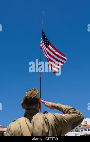 Mann im zweiten Weltkrieg U.S. Armee uniform grüßt die amerikanische Flagge Stockfoto