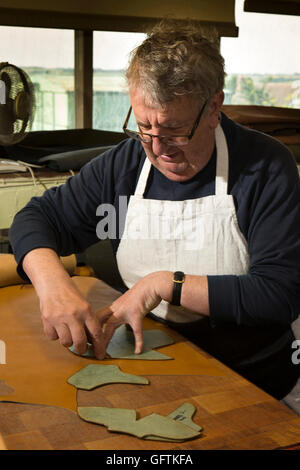 Großbritannien, England, Northamptonshire, Earls Barton, Barker, Kevin Mason Arbeiter Hand schneiden Schuh Obermaterial aus Leder Stockfoto