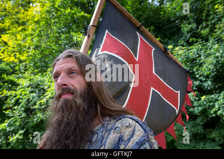 Ein Mann, gekleidet wie ein Wikinger Pflege eine Fahne, Moesgaard, Århus, Dänemark Stockfoto