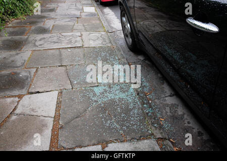 Glasscherben auf dem Gehweg Bürgersteig neben ein Auto, das eingebrochen worden. 1. August 2016 Stockfoto