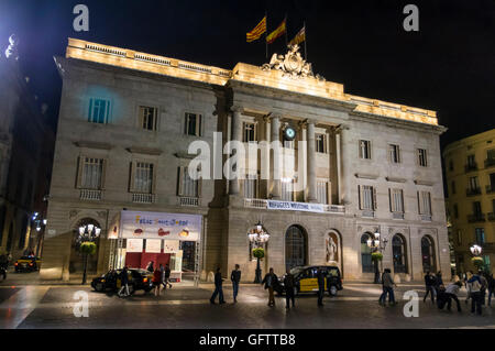 Fassade der Casa De La Ciutat, Rathaus von Barcelona, in der Nacht, mit einem Banner "Flüchtlinge aufzunehmen". Stockfoto