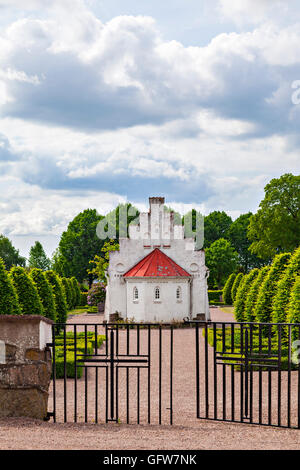 Bild des kleinen weißen Kapelle durch das Dorf Kirche von Norra Vram, Schweden. Stockfoto