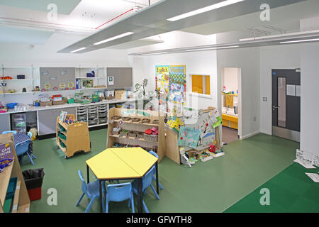 Kindergarten Klassenzimmer in einer neuen, London-Grundschule. Tische und Stühle mit Schülers Kunstwerken zeigt an den Wänden Stockfoto