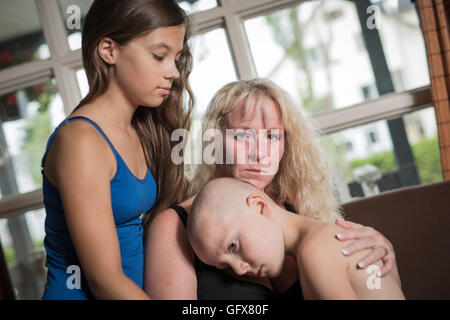 Mutter umarmt weinend Wohnzimmer Sohn Stockfoto