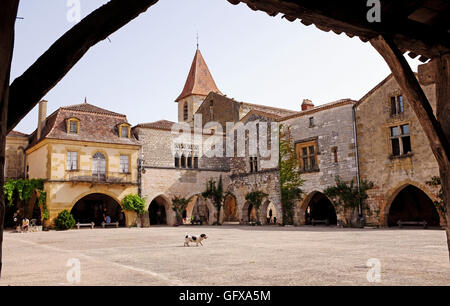 Ein kleiner Hund spaziert über den berühmten Platz in der schönen Bastide von Monpazier in der Dordogne Region Südwestfrankreich Stockfoto