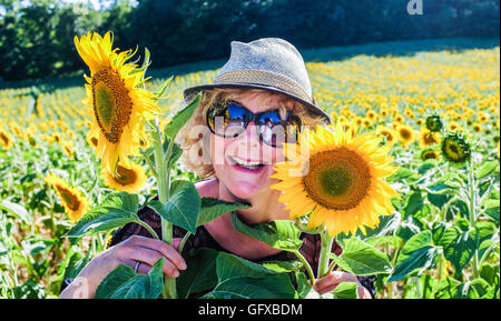 Frau geht in einem Feld von Sonnenblumen in Frayssinet le-Gelat in Le viel Region Abteilung Frankreich Stockfoto
