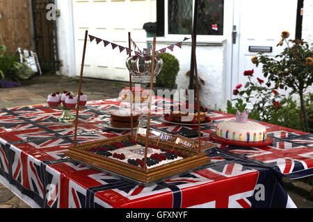 Straße Partei Held zur Feier von Königin Elizabeth II 90. Geburtstag - Kuchen am Tisch mit Union Jacks Cornwall Straße Surrey deu Stockfoto