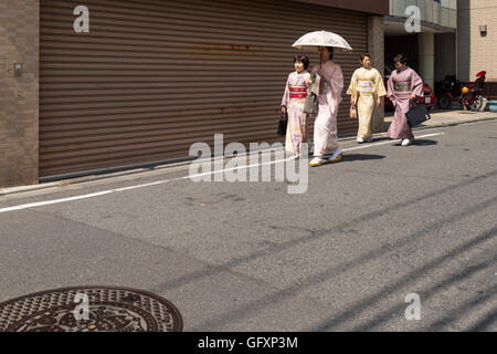 Japanische Frauen in Tracht gekleidet und zu Fuß auf der Seite einer kleinen Straße in der Nähe Ueno Park in Tokio. Stockfoto