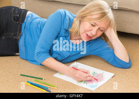 ältere Frau, die Färbung in ein Buch Stockfoto