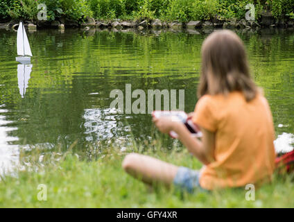 Mädchen mit remote gesteuerten Boot Stockfoto