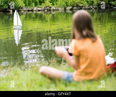 Mädchen mit remote gesteuerten Boot Stockfoto