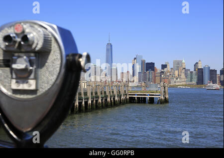 Blick auf die Skyline von Lower Manhattan Financial District mit einer Münze betrieben Fernglas im Vordergrund. New York City, USA Stockfoto