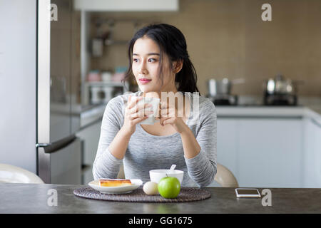 Junge Chinesin frühstücken zu Hause Stockfoto