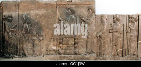 227. KALKSTEIN RELIEF DES KÖNIGS DARIUS SITZT AUF THRON, KRONPRINZEN XERXES, WACHEN UND ATENDANTS HINTER IHM.  PERSEPOLIS, CA. 5 Stockfoto