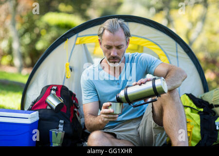 Wanderer, gießt Wasser aus der Thermoskanne Stockfoto