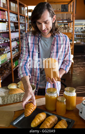 Mann Brotkauf Croissant vom Display-counter Stockfoto