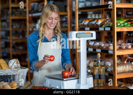 Weibliches Personal Gewichtung Gemüse im Maßstab Stockfoto