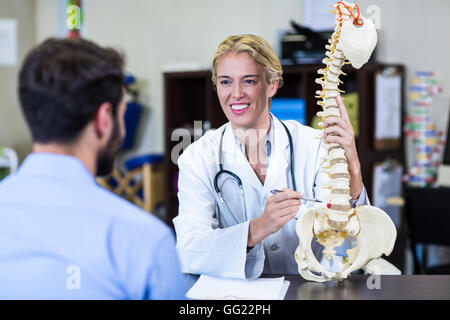 Physiotherapeut, Patienten zu erklären, Wirbelsäule Modell Stockfoto