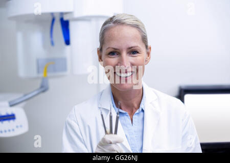 Porträt von Zahnärztin hält Dentalwerkzeuge Stockfoto