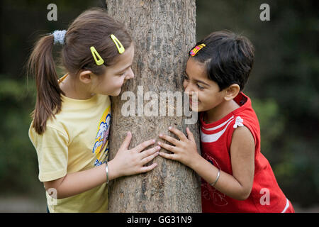 Mädchen umarmt einen Baum Stockfoto