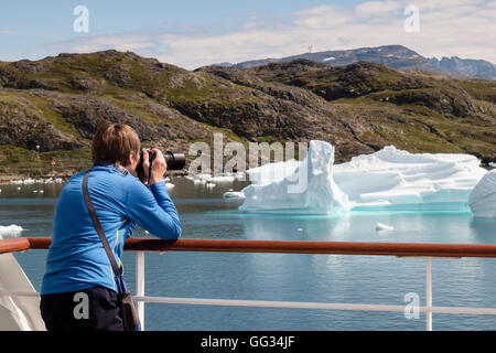 Pensionierte touristische Fahrgast mit einer Kamera fotografieren Eisberge und Landschaft von einem Kreuzfahrtschiff in Tunulliarfik Fjord im Sommer 2016. Narsaq Grönland Stockfoto