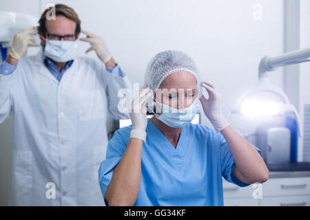 Zahnarzt und Zahnarzthelferin Mundschutz tragen Stockfoto