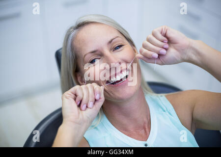 Frau, die ihre Zähne Zahnseide Stockfoto