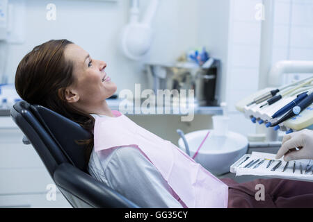 Zahnarzt Abholung zahnärztliche Instrumente, eine Patientin zu untersuchen Stockfoto