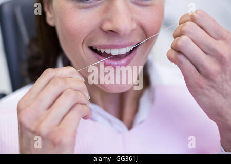 Patientin, die ihre Zähne Zahnseide Stockfoto