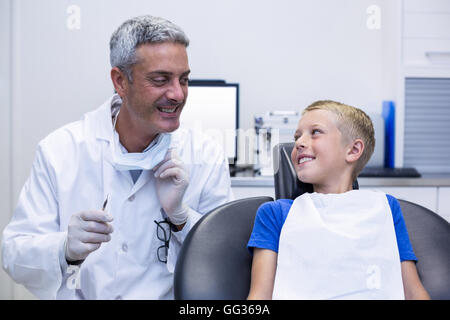 Zahnarzt im Gespräch mit jungen Patienten lächelnd Stockfoto