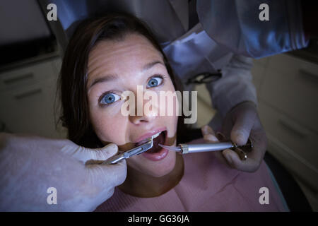Zahnarzt untersucht eine Patientin mit Werkzeugen Stockfoto