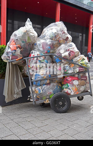 Ein transparente Müllsäcke voller Wagen sitzt auf dem Bürgersteig Stockfoto