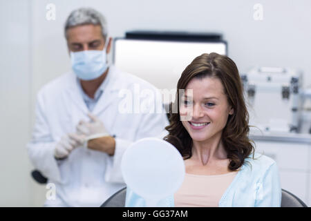 Patienten, die ihre Zähne im Spiegel überprüfen Stockfoto
