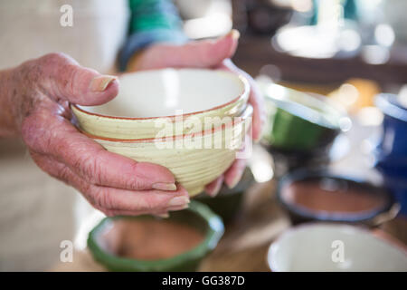 Nahaufnahme von weiblichen Potter hält Schüssel Stockfoto