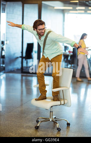 Männliche Business executive stehen auf Stuhl Stockfoto