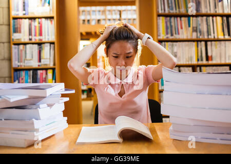 Gespannten junge Frau studieren in Bibliothek Stockfoto