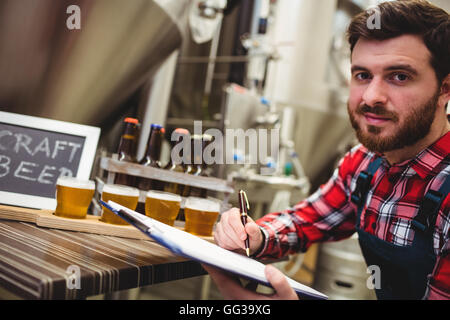 Hersteller schreiben während der Prüfung Bier in der Brauerei Stockfoto