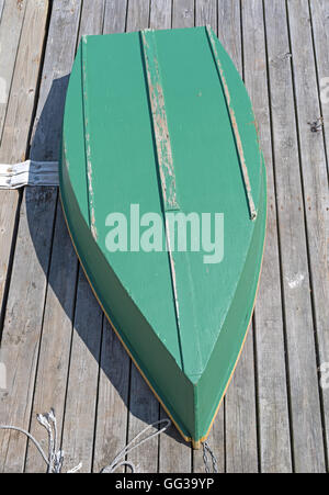 Der Rumpf von einem grün lackiertem Sperrholz Skiff kopfüber auf einem Deck. Stockfoto