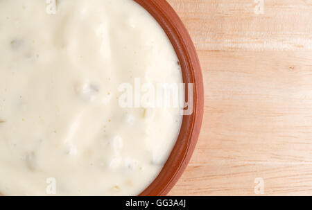 Enge Draufsicht ein kleiner Ton-Schale mit Sauce Tartar auf einem Holztisch. Stockfoto