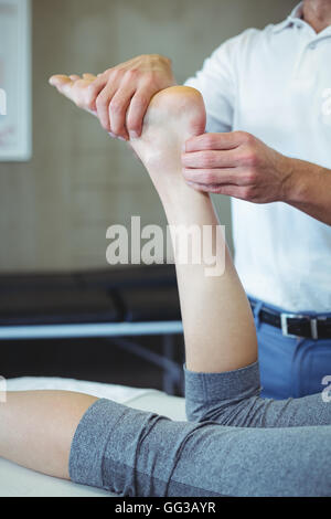 Frau empfangende Fußmassage von Physiotherapeuten Stockfoto