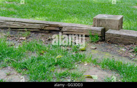 alte und verlassene Holzzaun auf einer Wiese mit Rasen bedeckt Stockfoto