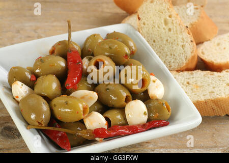 Schüssel mit grünen Oliven mit Knoblauch und Jalapeno Paprikaschoten Stockfoto