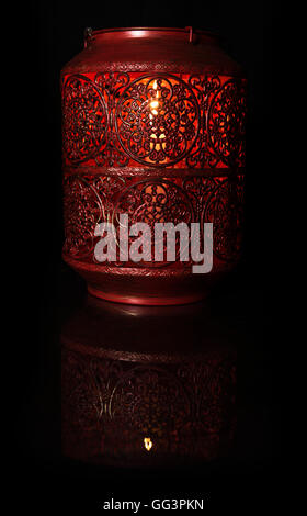 rote Kerze Lampe mit weißen Kerze auf schwarzem Hintergrund auf sein eigenes Spiegelbild Stockfoto