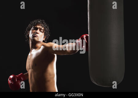 Männlicher Boxer schlagen schwere Tasche Stockfoto