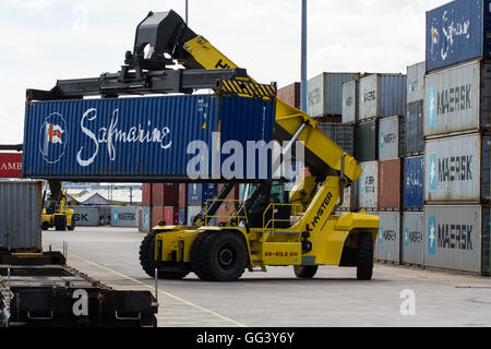 Ein schweres Anheben der Maschine Be- und Entladen von Fracht und Versand von Containern auf Güterzüge in einem Rail port oder Güterbahnhof. Stockfoto